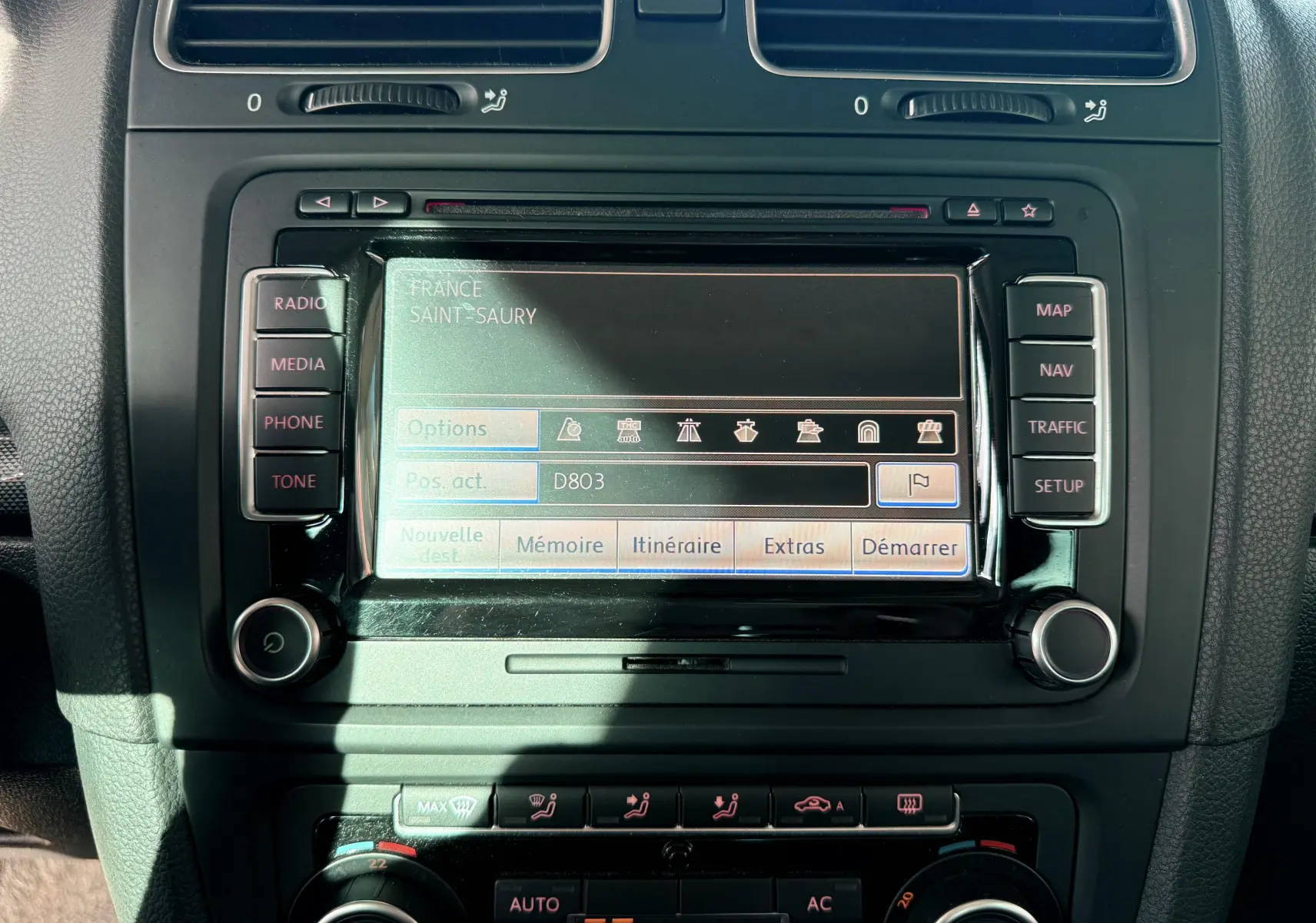 Écran de navigation central avec commandes radio et climatisation dans une Volkswagen Golf blanche de 2012