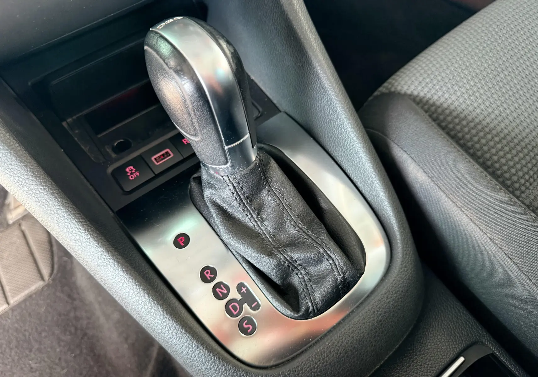 Gros plan sur le levier de vitesses automatique noir de la Volkswagen Golf 1.4 TSI 2012, avec console grise et siège tissu gris.