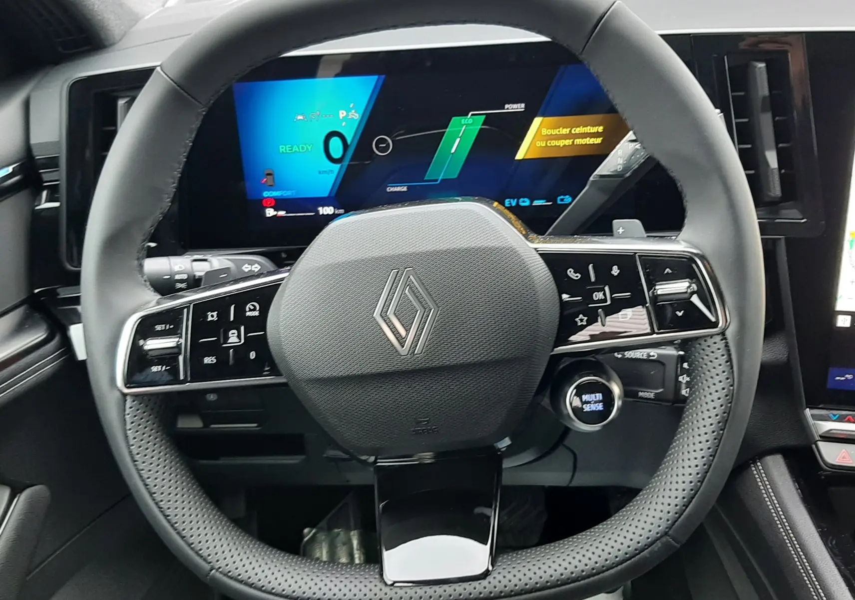 Vue intérieure centrée sur le volant multifonction du Renault Austral Ph.2, avec tableau de bord numérique allumé.