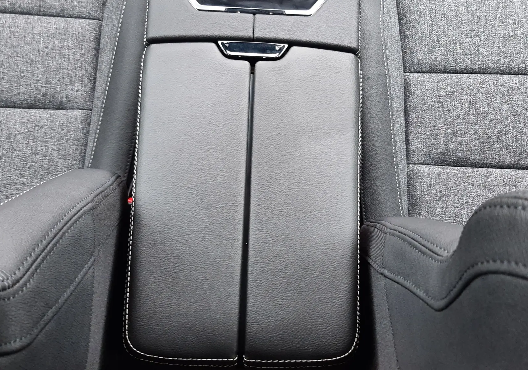 Vue plongeante sur la console centrale en cuir noir avec surpiqûres blanches du Renault Austral Ph.2 gris schiste, sièges tissu gris.