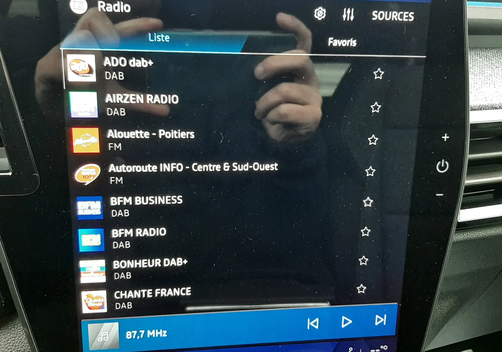 Écran tactile central du Renault Austral Ph.2 gris schiste, affichant la liste des radios DAB et FM, intérieur moderne.
