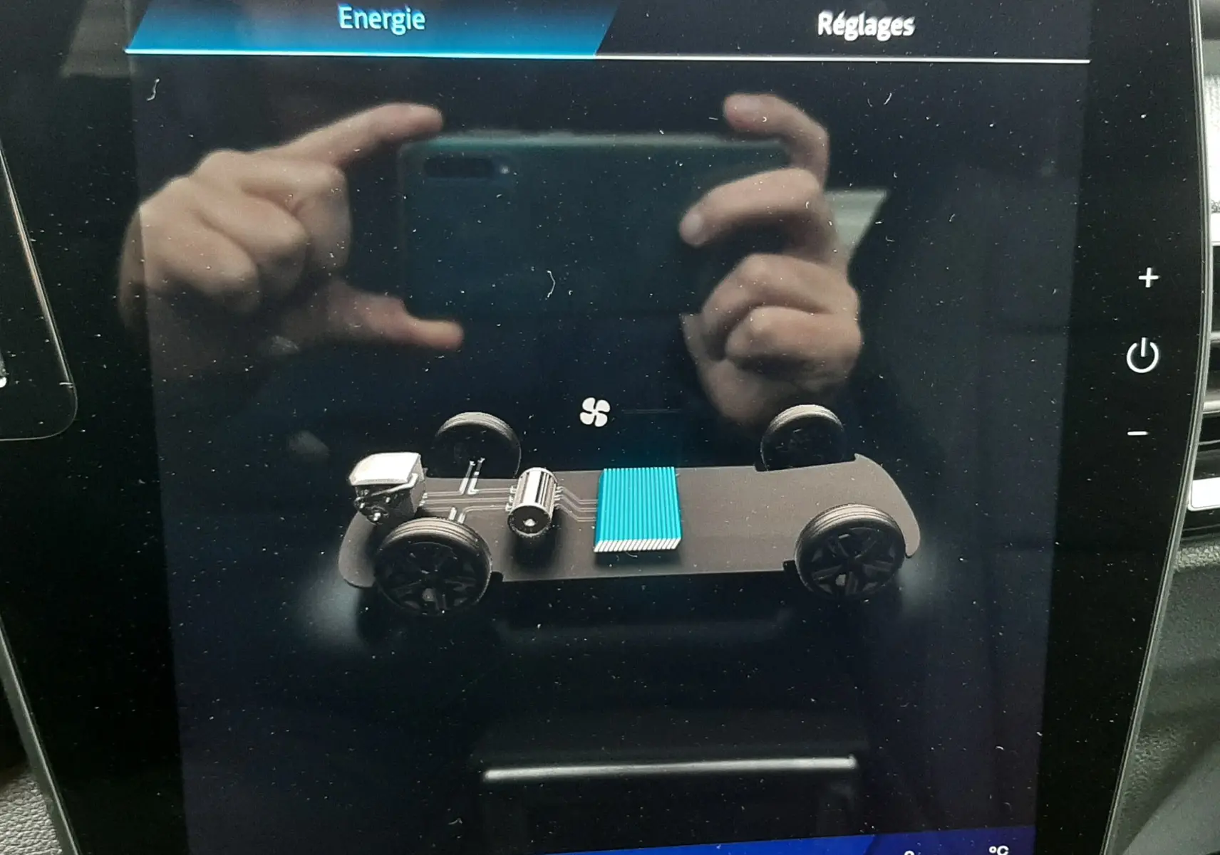 Écran tactile intérieur montrant la représentation 3D du châssis électrique du Renault Austral gris schiste, version hybride.