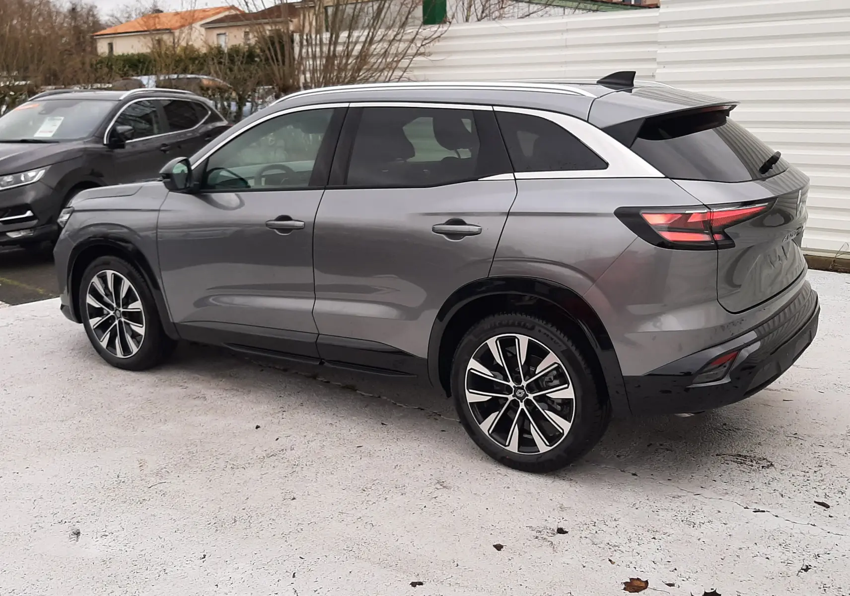 Vue 3/4 arrière droite du Renault Austral Ph.2 gris schiste avec jantes alliage bicolores et toit noir.