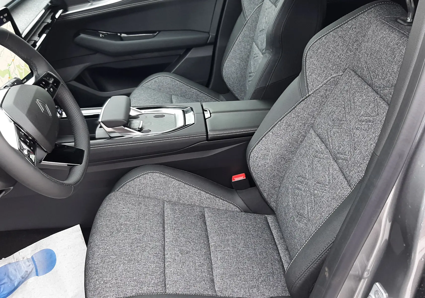 Vue intérieure côté conducteur du Renault Austral Ph.2 gris schiste, sièges tissu gris avec surpiqûres et console centrale moderne.