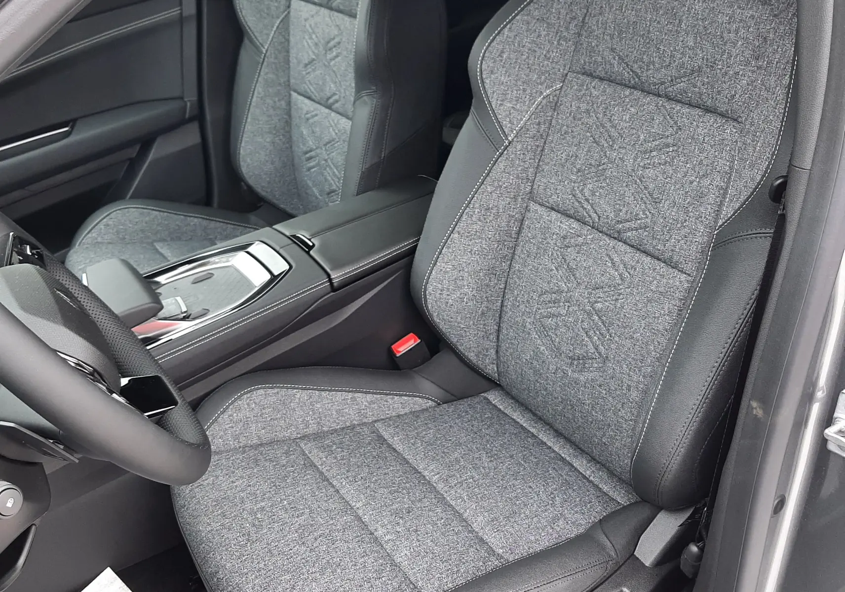 Vue intérieure côté conducteur du Renault Austral Ph.2 gris schiste, sièges tissu gris avec surpiqûres et cuir noir.