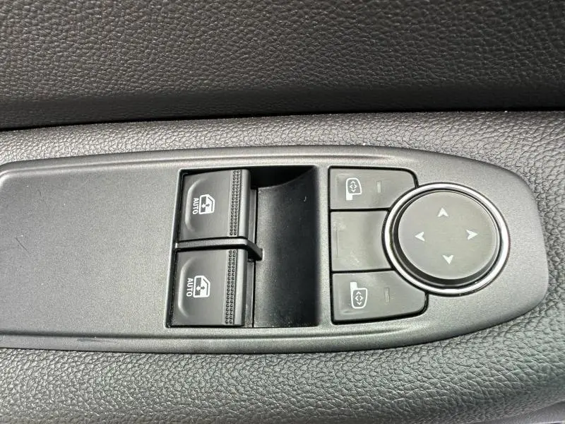 Gros plan sur les commandes de lève-vitres et réglage des rétroviseurs côté conducteur de la Renault Clio Gris Schiste 2023.