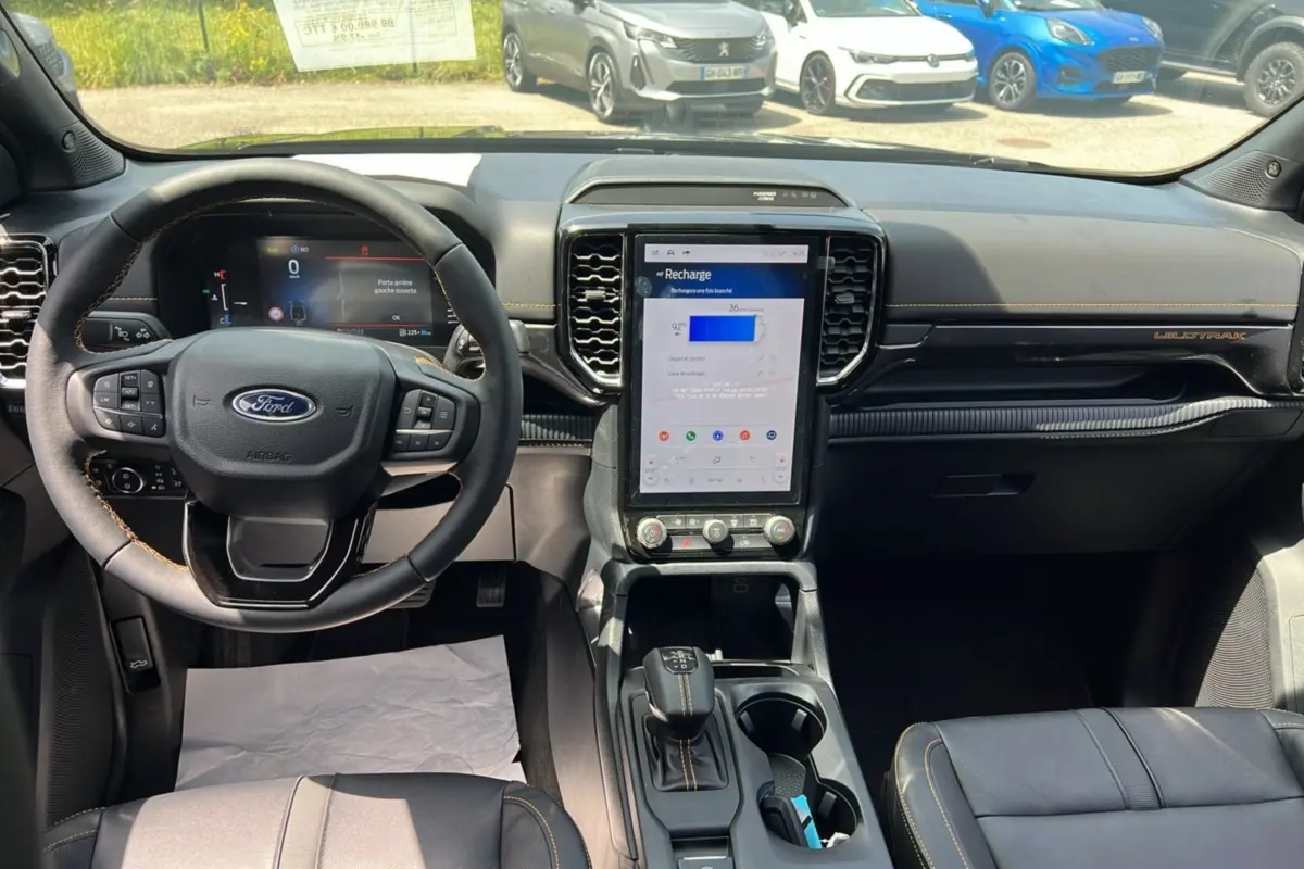 Intérieur du Ford Ranger Wildtrak 2026, vue du poste de conduite avec écran central vertical et volant cuir multifonctions.