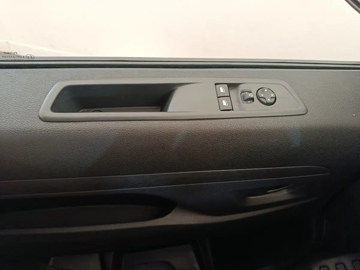 Détail de la commande des vitres et rétroviseurs sur la portière côté conducteur d’un Citroën Jumpy gris foncé 2025.