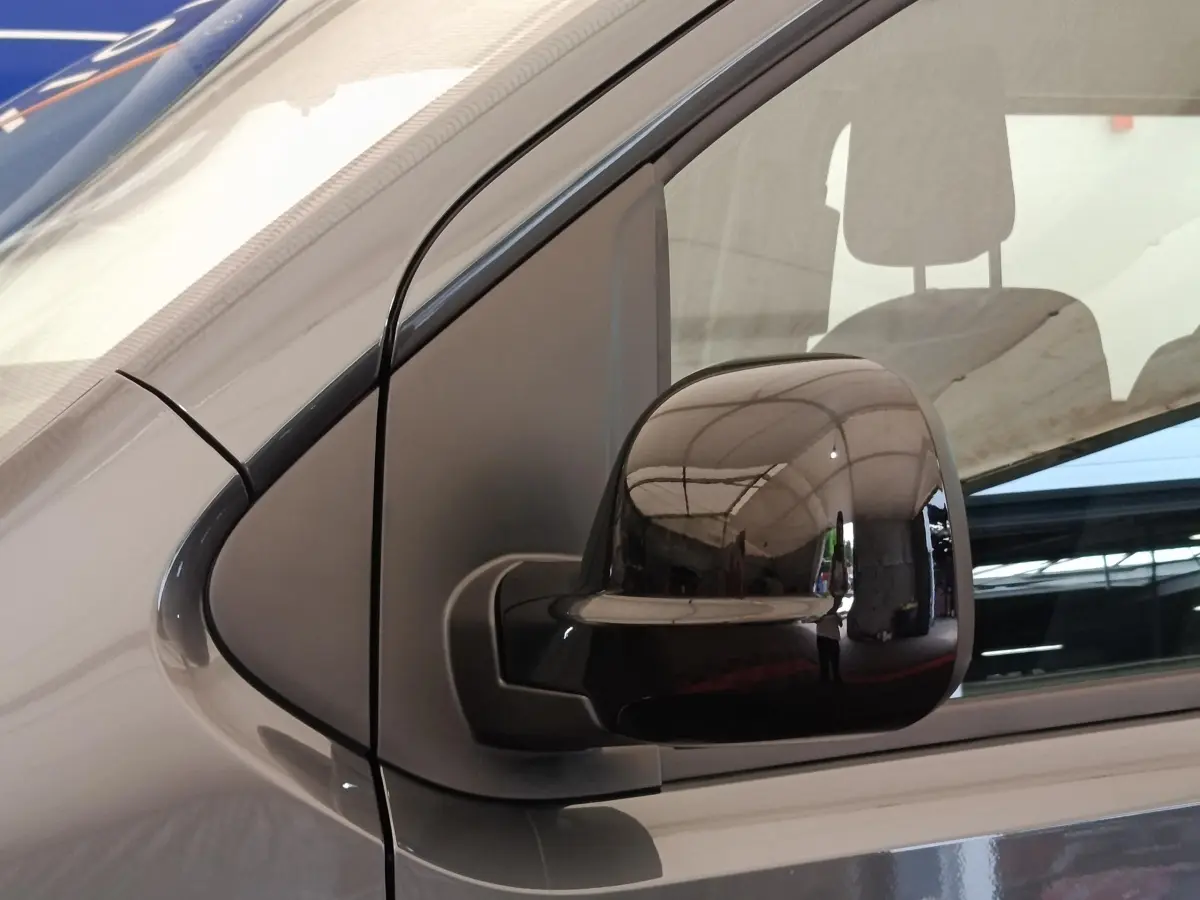 Gros plan sur le rétroviseur droit noir brillant d’un Citroën Jumpy gris foncé, vue latérale côté passager.