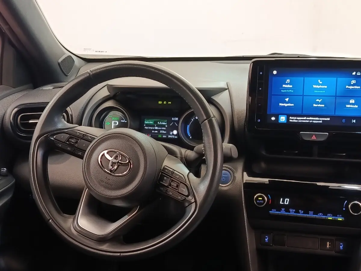 Vue intérieure frontale du tableau de bord de la Toyota Yaris Cross 2022 avec volant cuir et écran tactile central.