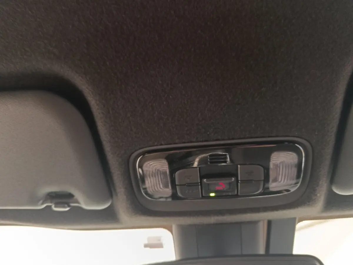 Plafonnier intérieur avec commandes d’éclairage et appel d’urgence dans une Toyota Yaris Cross blanche, vue de dessous.