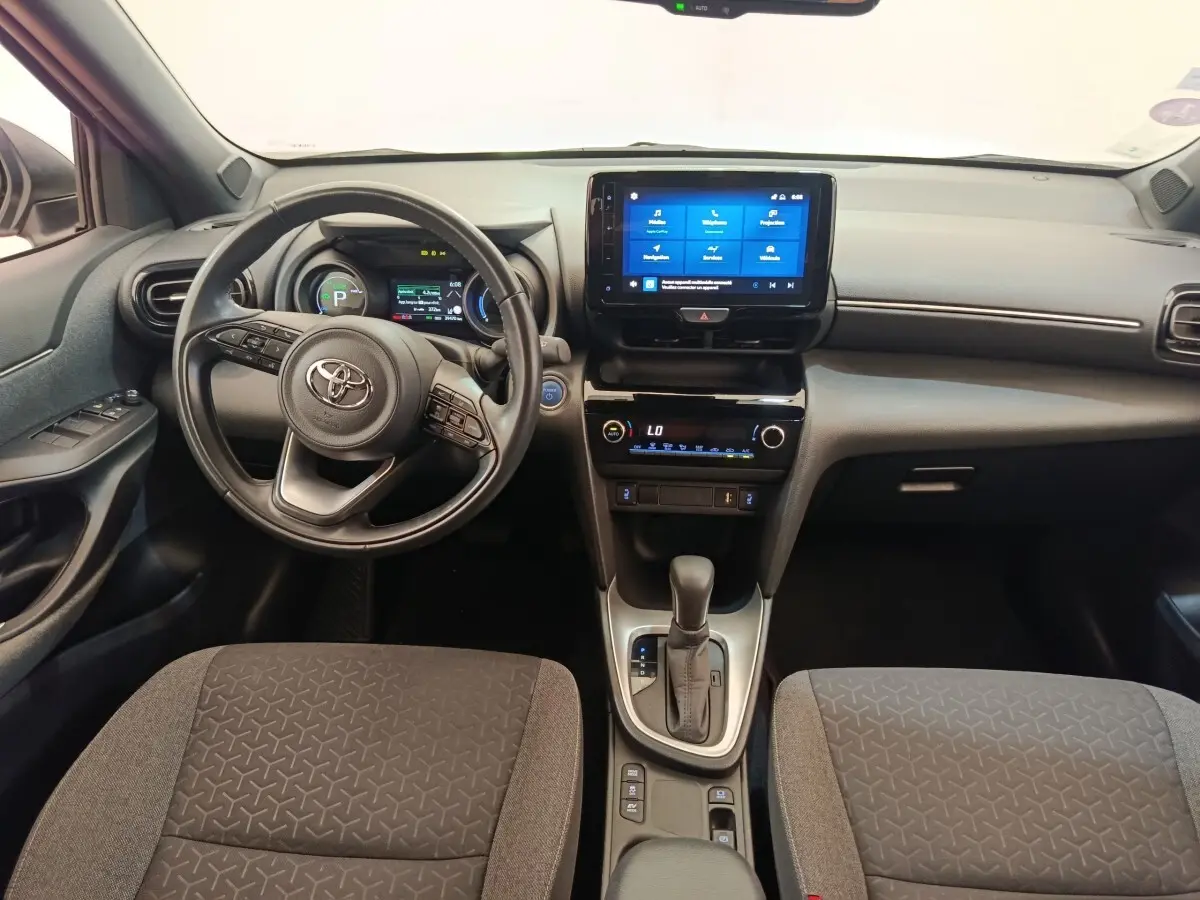 Vue intérieure avant de la Toyota Yaris Cross 1.5 Hybrid 116h Design avec tableau de bord numérique et écran tactile central.