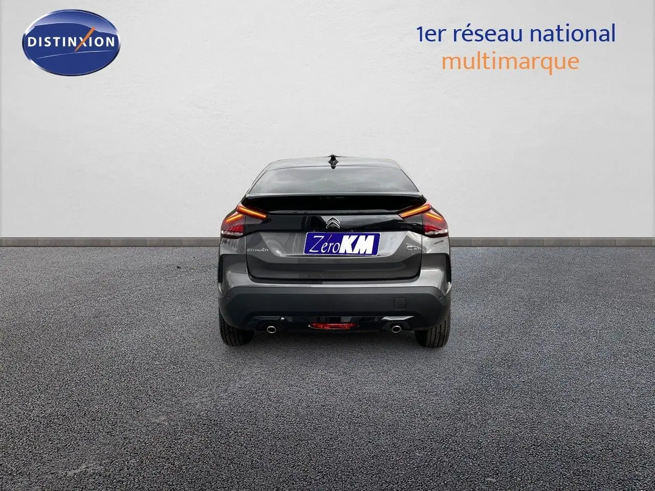 Vue arrière d'une Citroën C4 gris platinium métal 2024 avec feux LED et double sortie d'échappement visible.