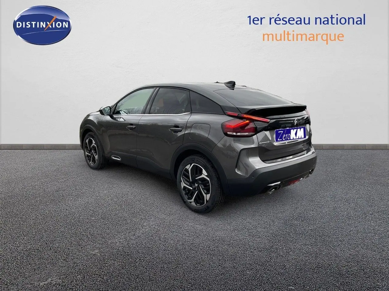 Vue 3/4 arrière droit d'une Citroën C4 gris platinium métal avec jantes biton et toit noir.