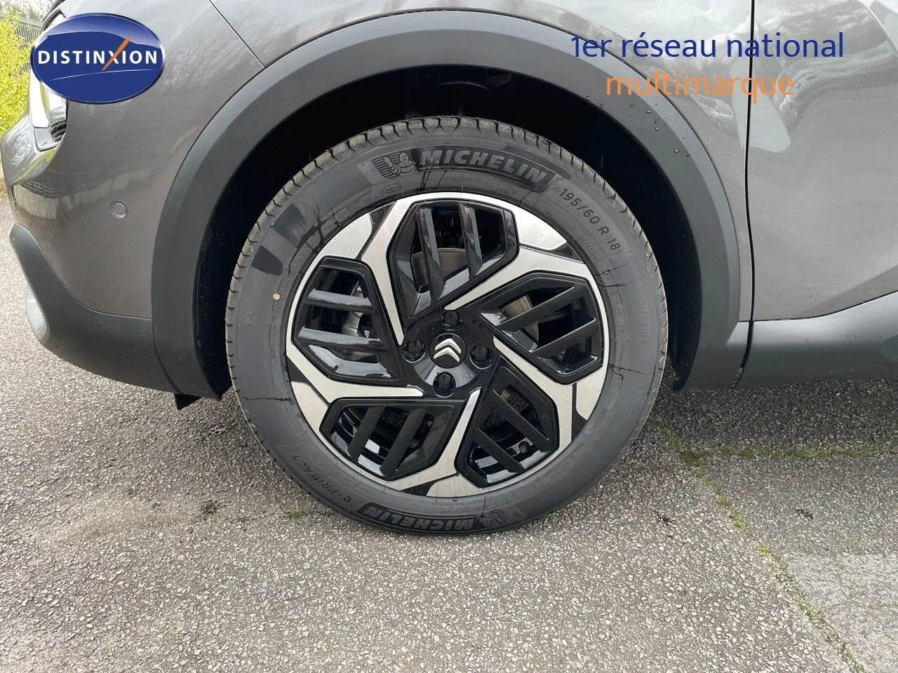 Gros plan sur la roue avant gauche de la Citroën C4 2024 gris platinium métal avec jante alliage bicolore distinctive.