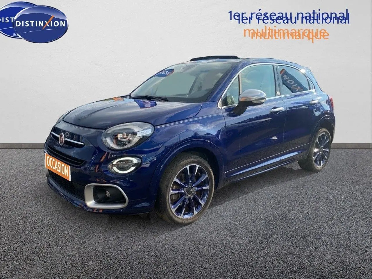Fiat 500X bleu Venezia métal en vue 3/4 avant droit, avec jantes bi-ton et détails chromés sur les rétroviseurs.