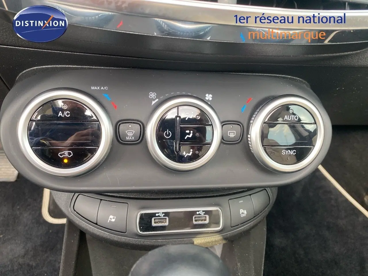 Commandes de climatisation et ports USB du tableau de bord du FIAT 500X bleu Venezia Metal, vue frontale rapprochée.