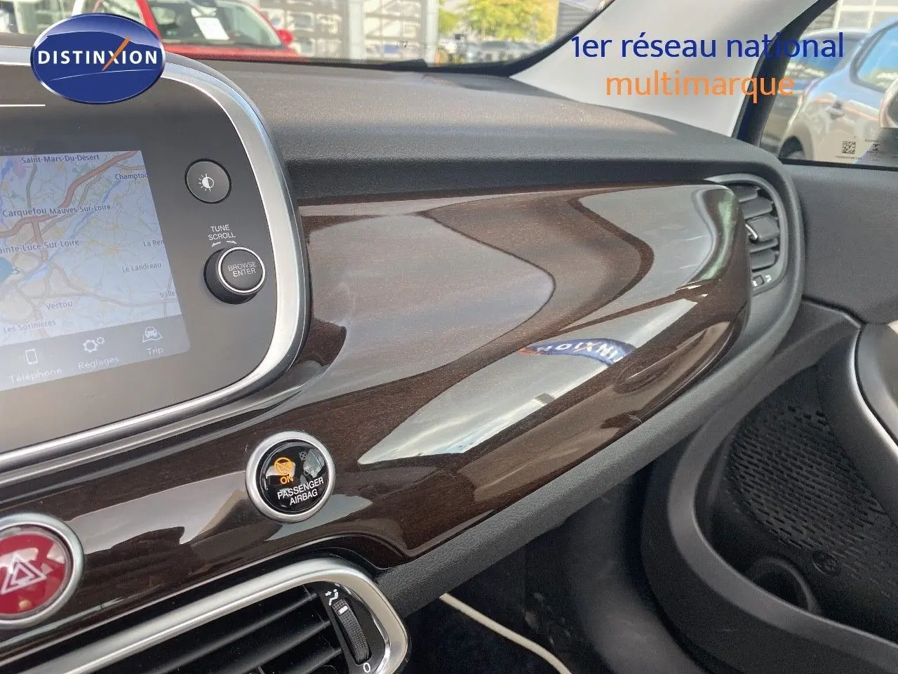 Tableau de bord intérieur de Fiat 500X 2021 avec finition bois brillant côté passager et écran tactile GPS.