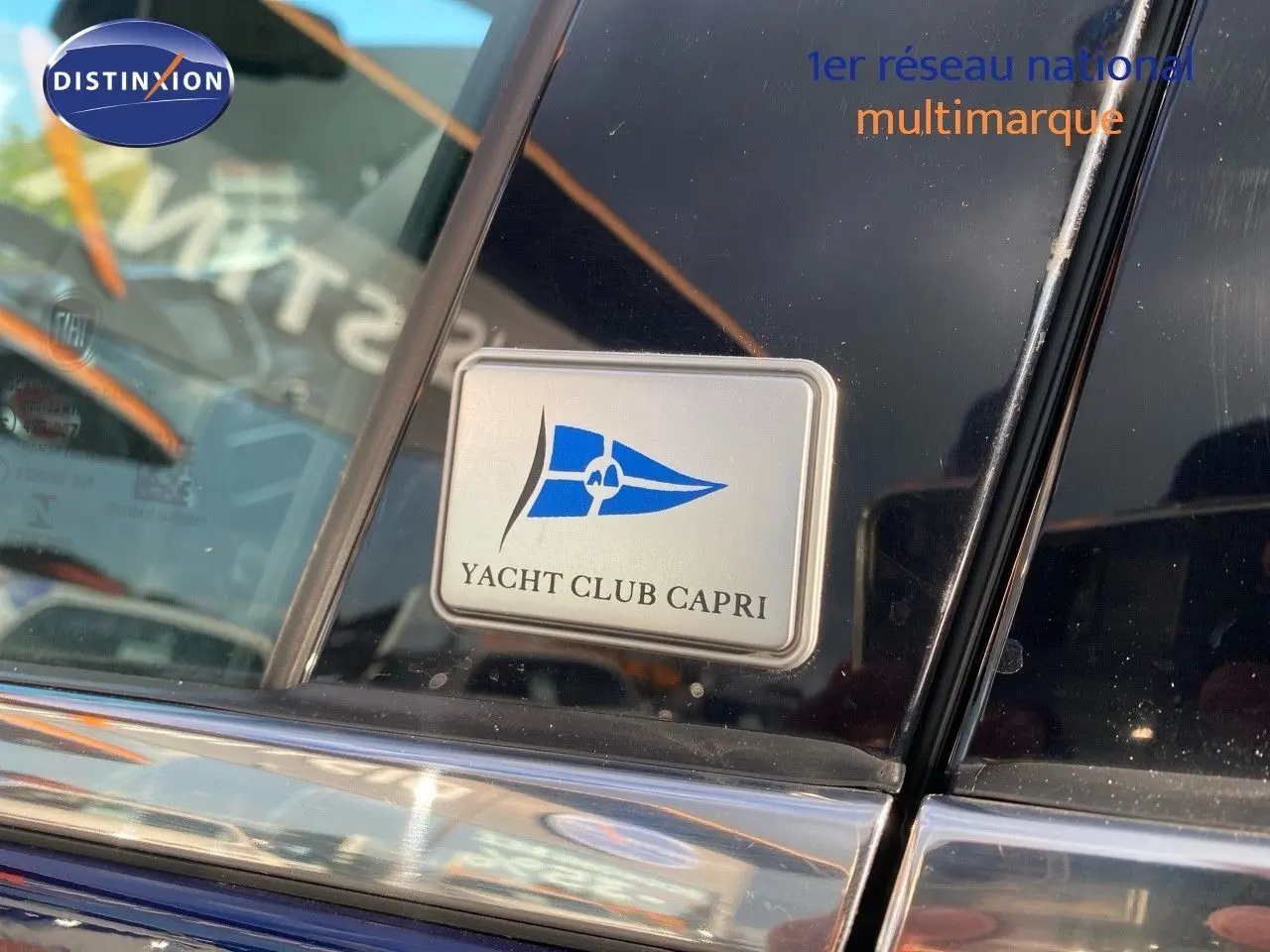 Gros plan sur l'autocollant Yacht Club Capri sur la vitre arrière côté droit d'une FIAT 500X Bleu Venezia Metal.