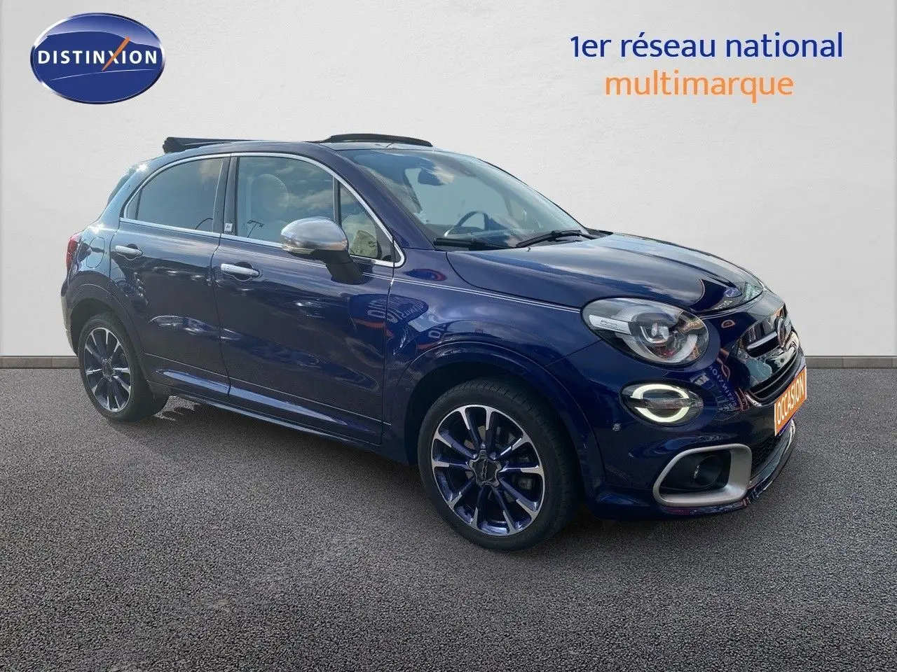 Vue 3/4 avant droite d'une FIAT 500X bleu Venezia métallisé avec jantes bi-ton et détails chromés sur les rétroviseurs.