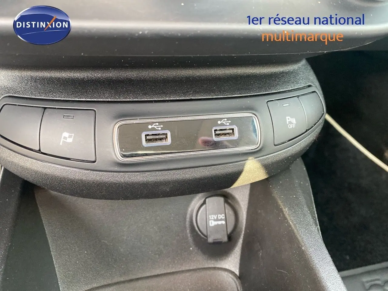 Vue rapprochée de la console centrale du Fiat 500X bleu Venezia, montrant les ports USB et commandes de stationnement.