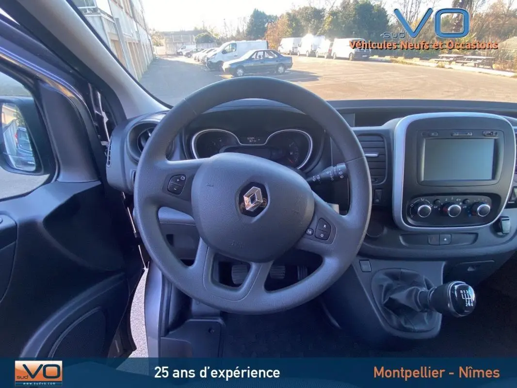 Vue intérieure frontale du Renault Trafic Combi gris clair 2019, volant multifonction et tableau de bord avec écran tactile.