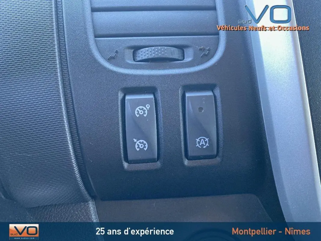 Gros plan sur les commandes du régulateur de vitesse et Stop & Start du Renault Trafic Fourgon gris clair, intérieur 2019.