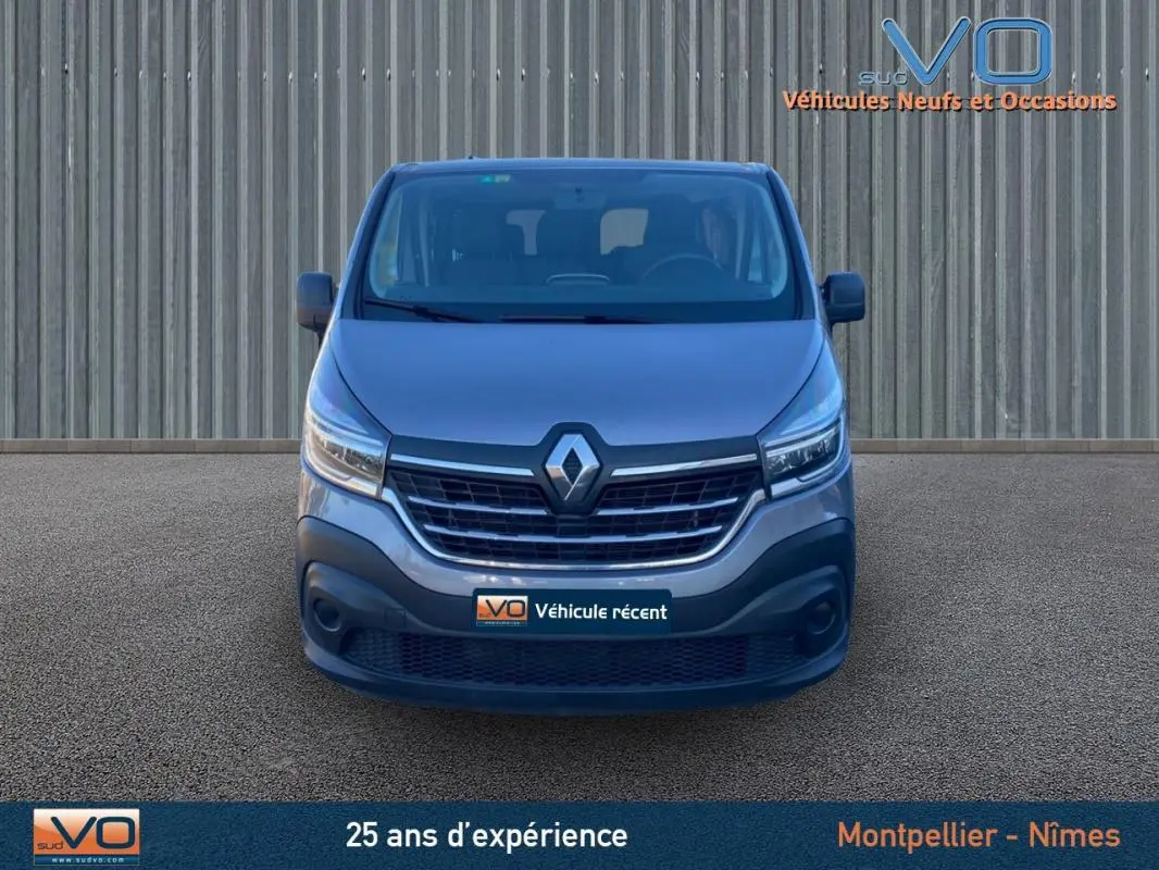 Vue frontale d'un Renault Trafic Fourgon gris clair de 2019 avec calandre noire et logo Renault bien visible.