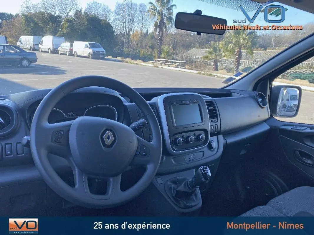 Intérieur du Renault Trafic Combi gris clair, vue côté conducteur sur tableau de bord et volant avec écran central.