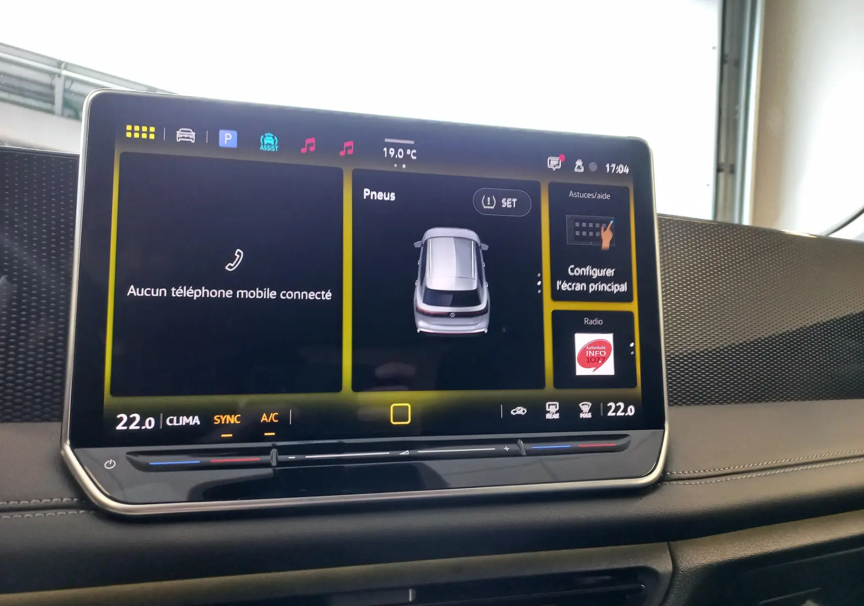 Tablette tactile du tableau de bord du Volkswagen Tiguan 2025 affichant la température et l'état des pneus.