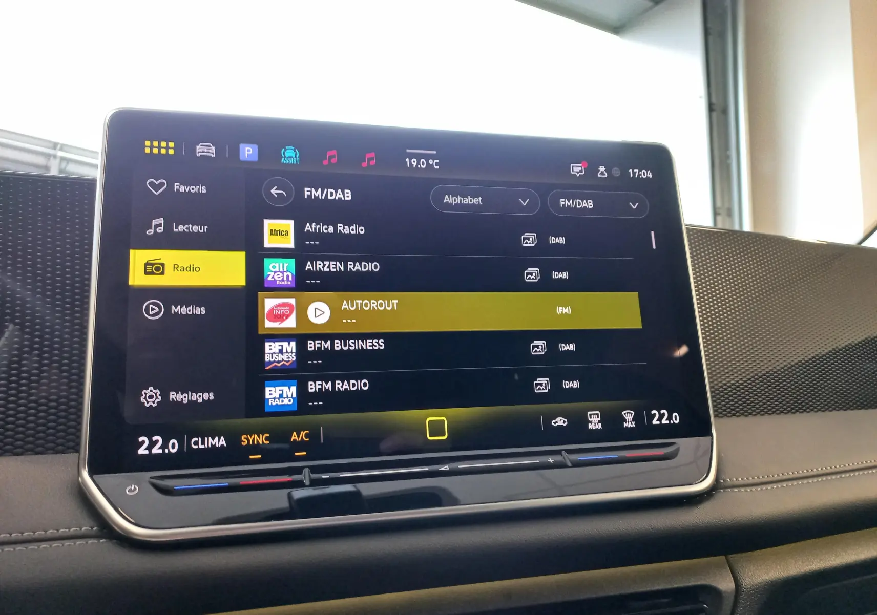 Écran tactile central du Volkswagen Tiguan 2025 affichant les options radio FM/DAB avec interface moderne et commandes climatiques intégrées