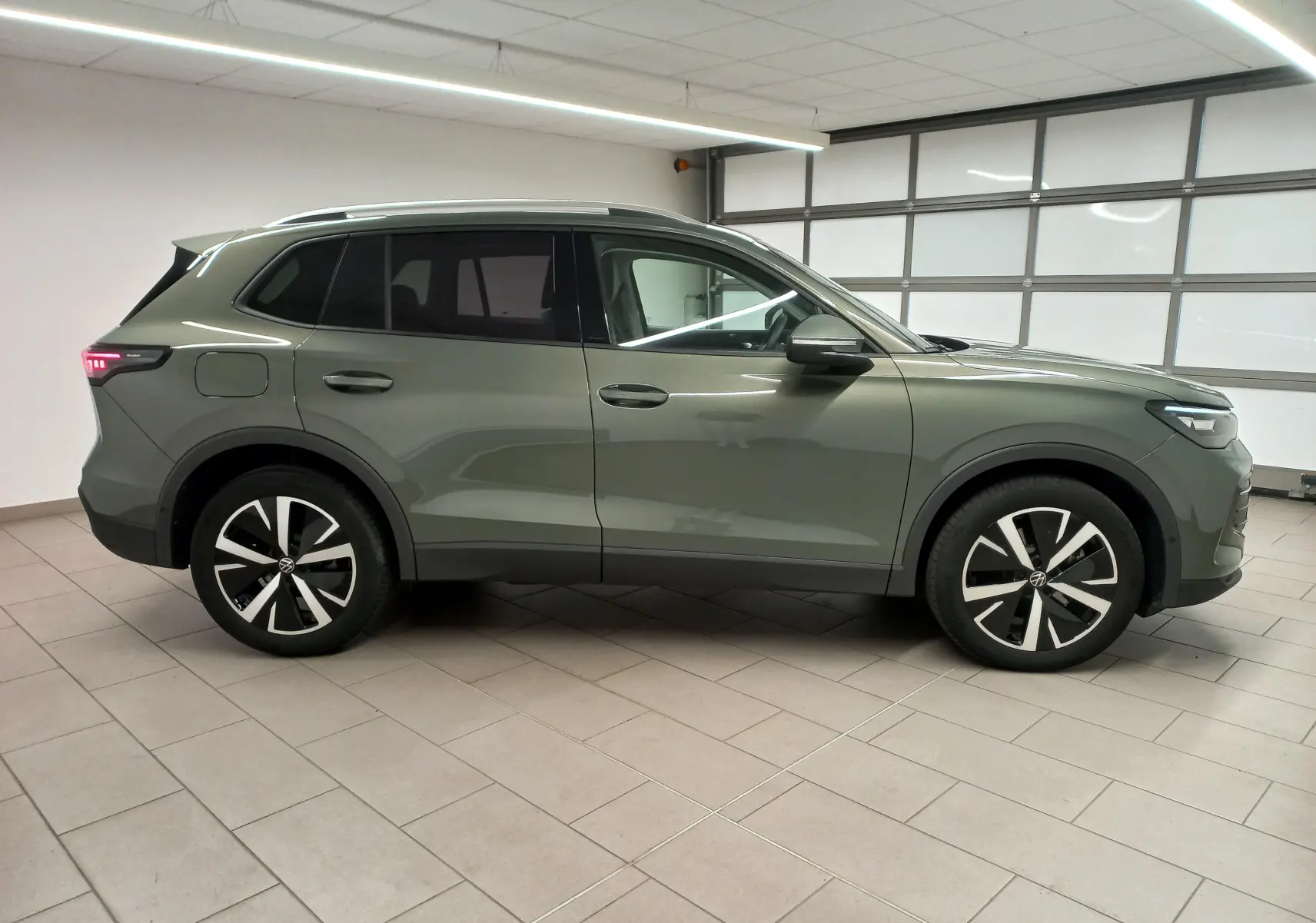 Volkswagen Tiguan 2025 vert Cipressino vu de profil côté gauche avec jantes alliage noir brillant Catania.