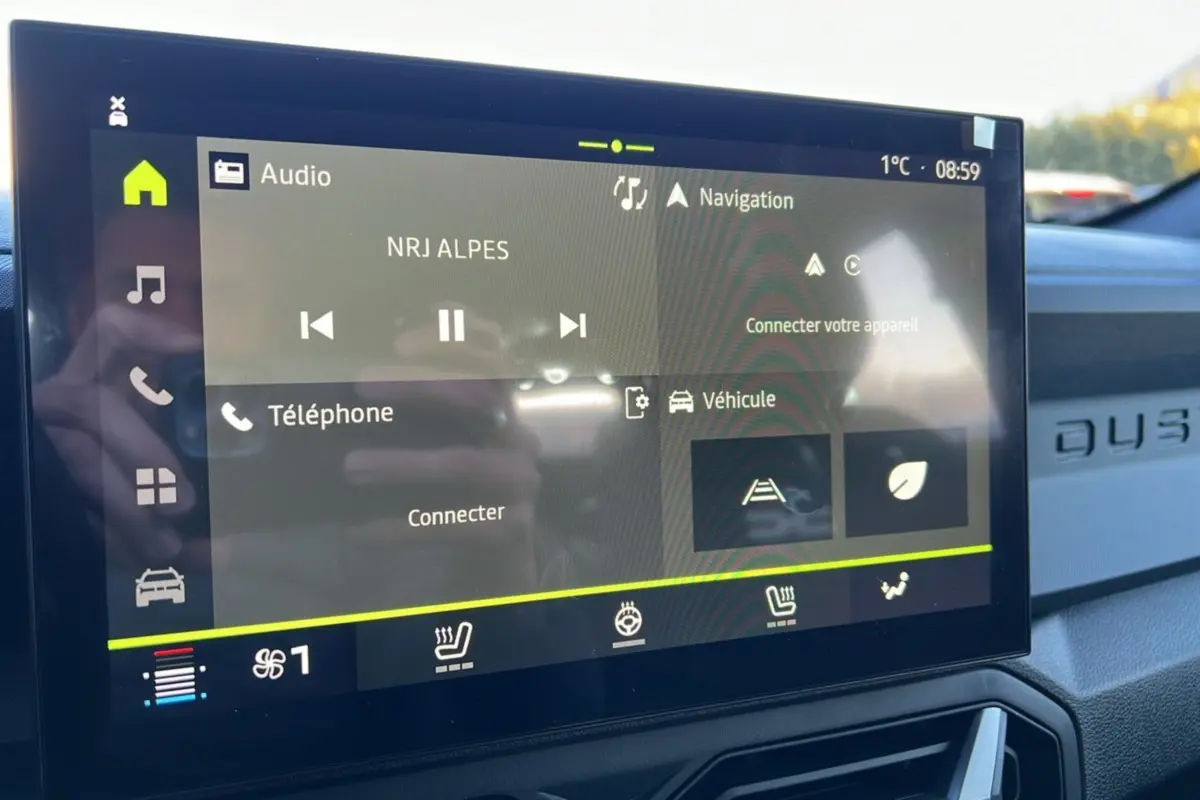 Écran tactile central du Dacia Duster kaki lichen 2025 affichant les commandes audio, navigation et véhicule.