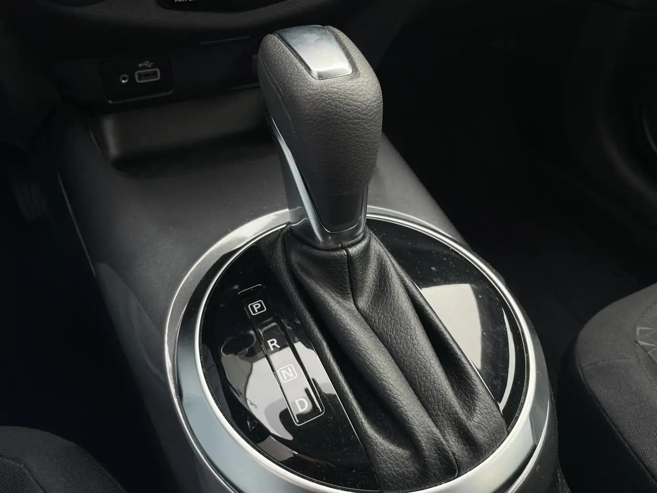 Le levier de vitesses automatique noir et argenté du Nissan Juke 2024 vu en gros plan dans l'habitacle.