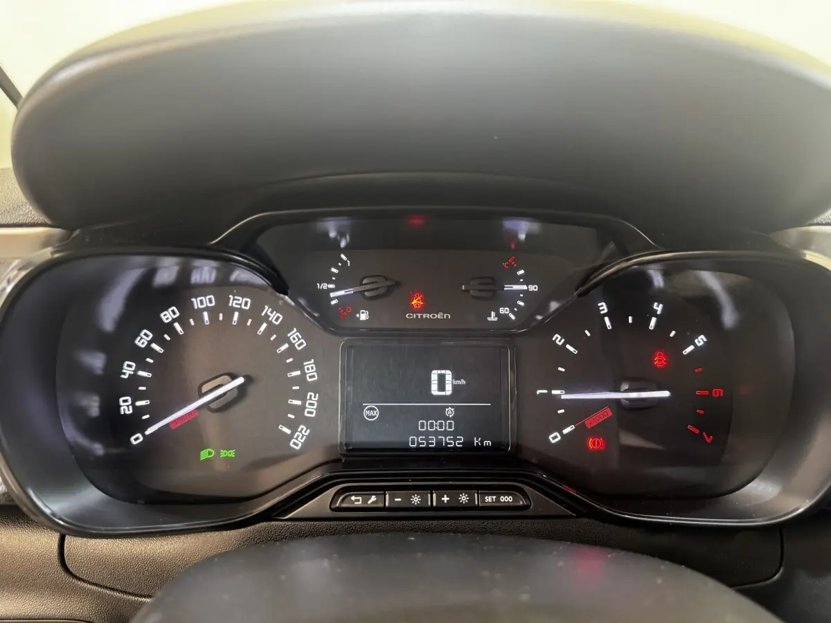 Vue rapprochée du tableau de bord de la Citroën C3 beige, affichant compteur, compte-tours et écran digital.