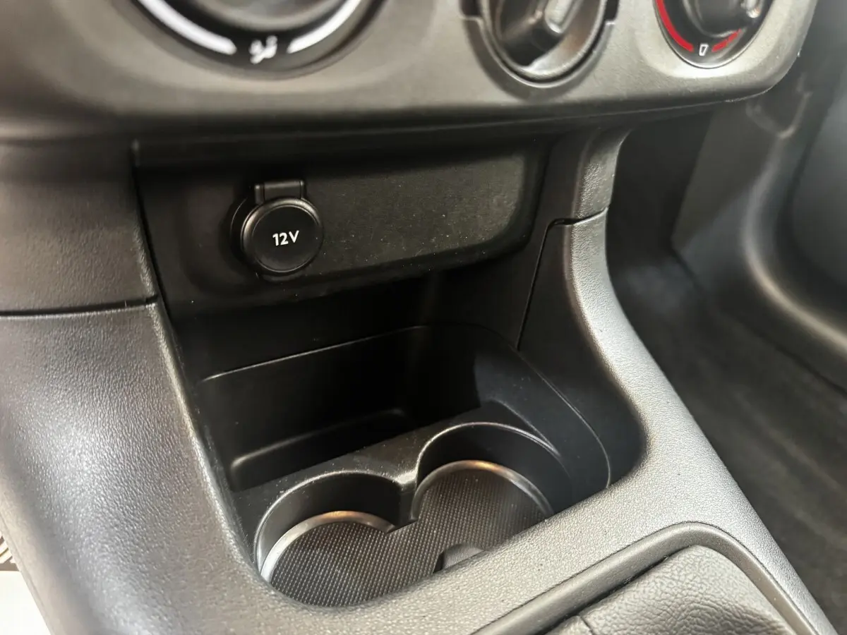 Gros plan sur la prise 12V et les porte-gobelets noirs dans l'habitacle de la Citroën C3 beige 2021.