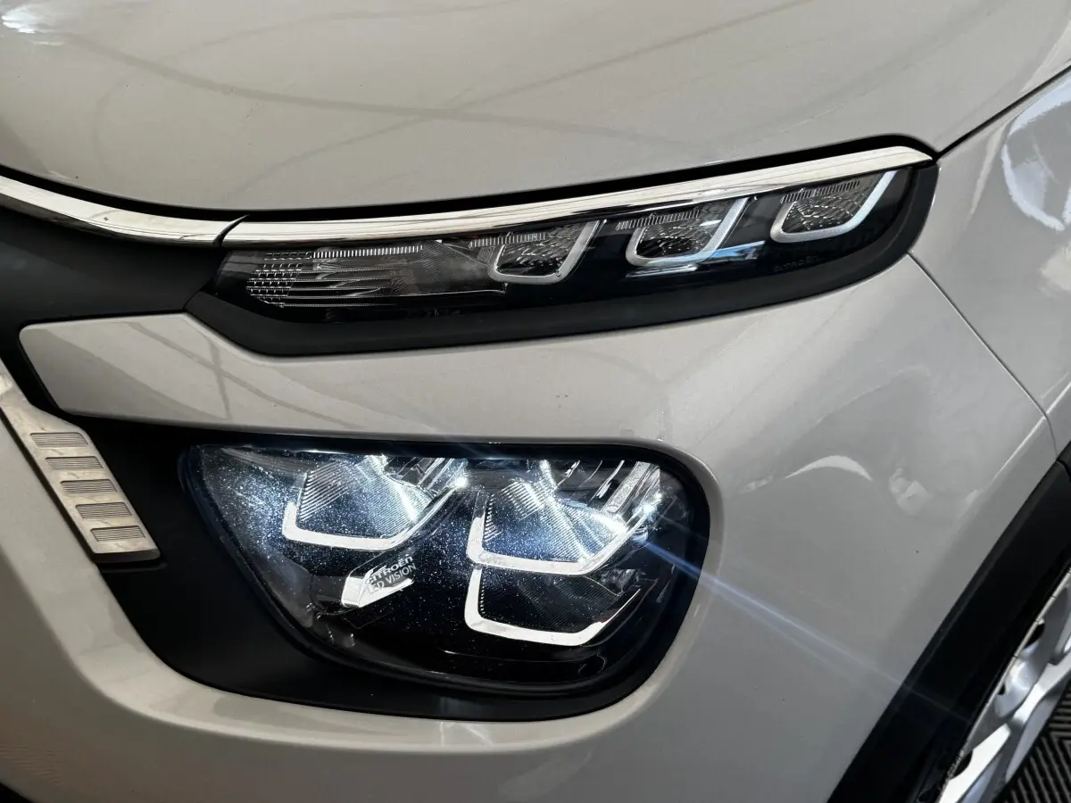 Gros plan sur le phare avant droit beige de la Citroën C3 PureTech 83 S&S BVM Feel 2021 avec feux LED distinctifs.