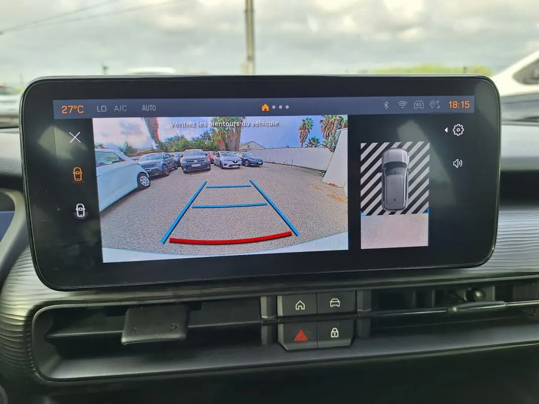 Écran intérieur montrant la caméra de recul avec vue arrière et angles de stationnement du Jeep Avenger blanc.