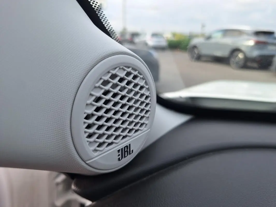 Gros plan sur l'enceinte JBL blanche intégrée au tableau de bord du Jeep Avenger 2025, intérieur clair visible.