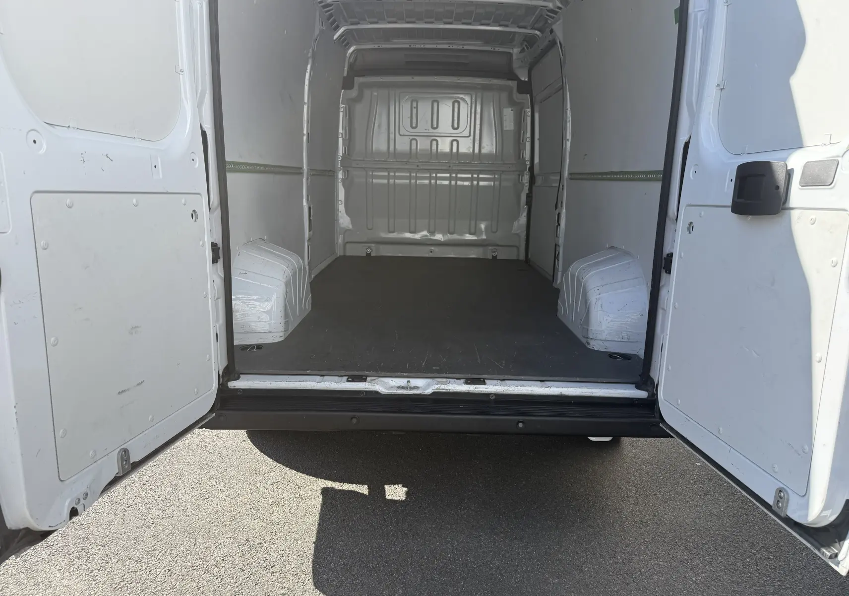 Vue arrière ouverte du fourgon blanc Opel Movano 2.2 BlueHDi 140 L3H2, montrant l’espace de chargement vide.