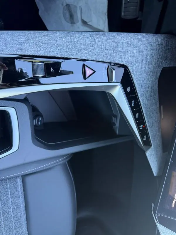 Détail de la console centrale du Peugeot 3008 Hybrid 145 e-DCS6 Allure 2025, avec finition tissu gris et commandes tactiles.