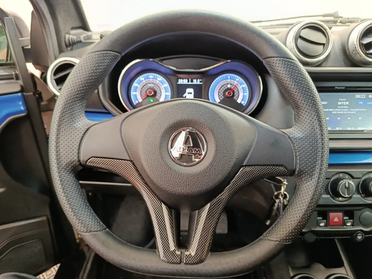 Vue rapprochée du volant noir et du tableau de bord lumineux de l'Aixam Ambition 0.5 City Coupe GTI 2023.