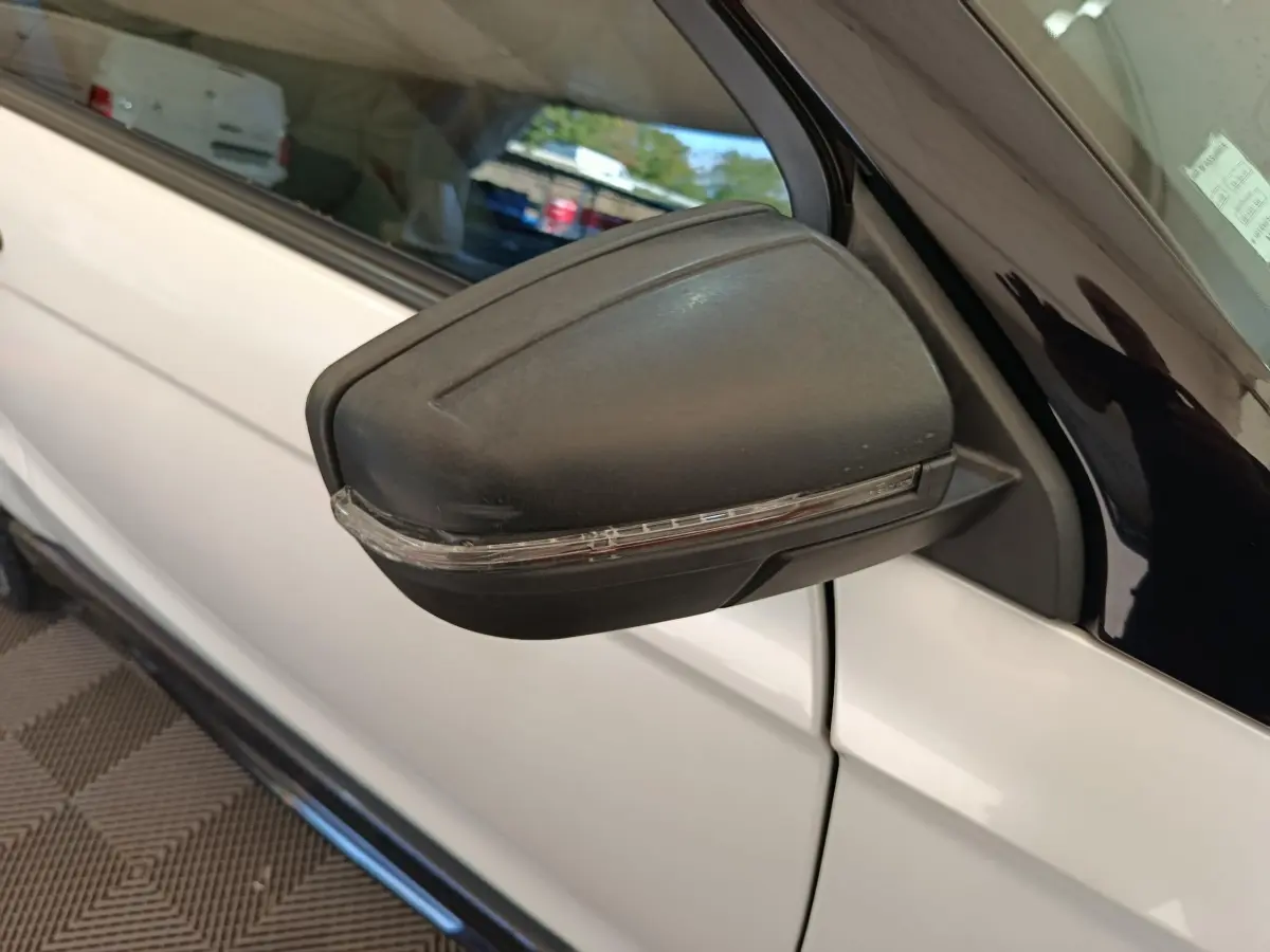Rétroviseur extérieur côté conducteur noir avec clignotant intégré sur Aixam Ambition blanc, vue rapprochée côté gauche.