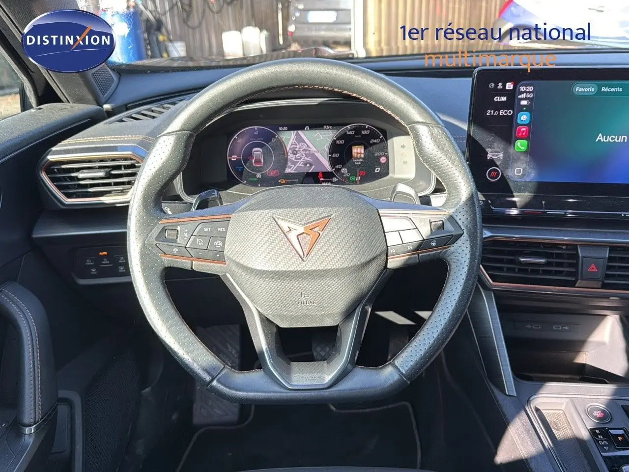 Vue intérieure centrée sur le volant en cuir noir perforé du CUPRA Formentor 1.4 E-HYBRID 2023 avec tableau de bord numérique.