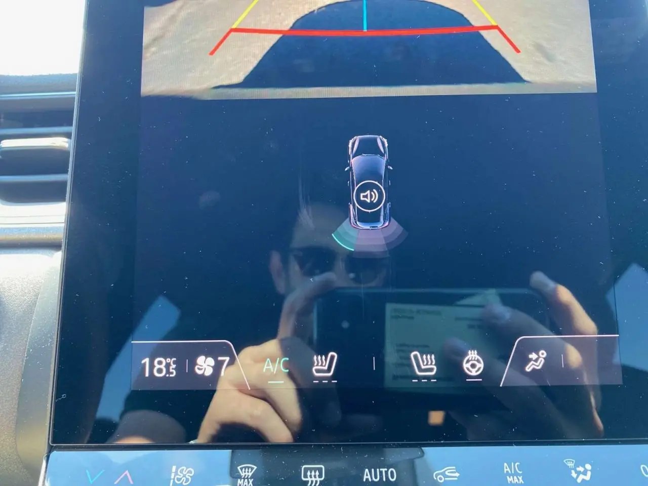 Écran tactile intérieur du Renault Captur 2025 montrant la caméra de recul et les commandes de climatisation et sièges chauffants.