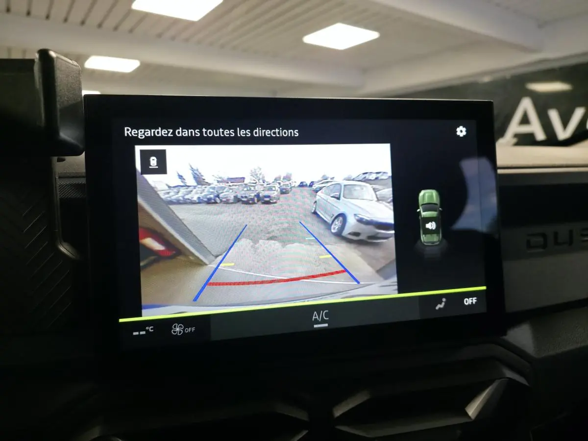 Vue intérieure de l'écran central tactile du Dacia Duster 2025 affichant la caméra de recul en marche.