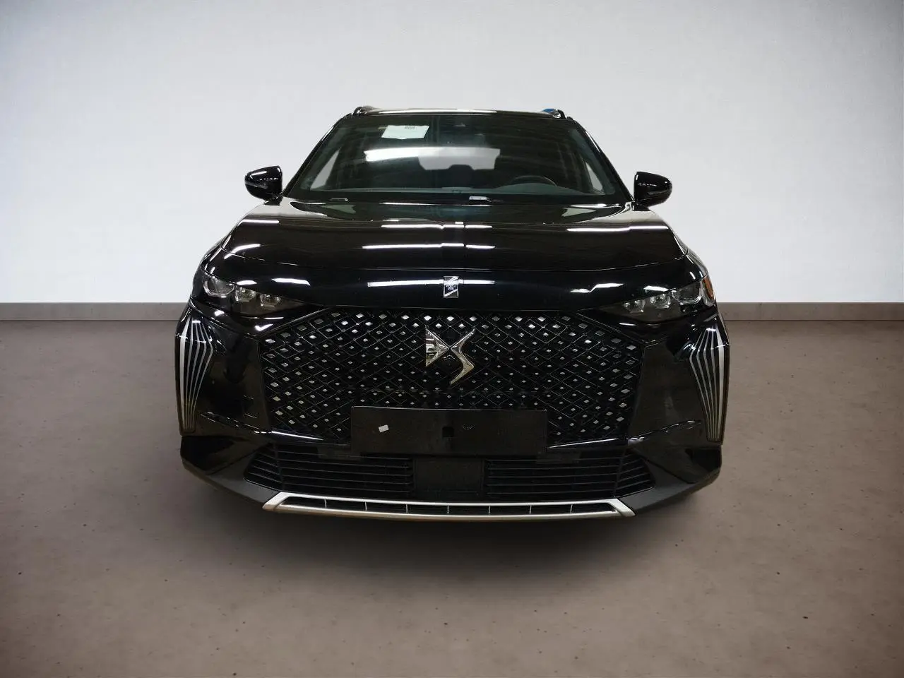 Vue frontale d'un DS7 noir Perla avec calandre distinctive DS Pixel LED et badge DS Etoile sur le capot.