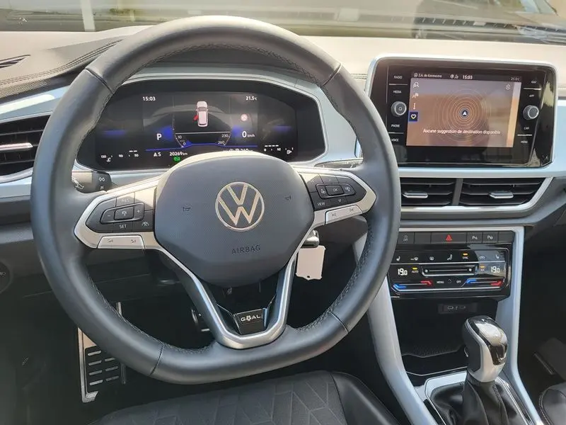 Vue intérieure centrée sur le volant noir du Volkswagen T-Roc 2025, avec tableau de bord digital et écran tactile multimédia.