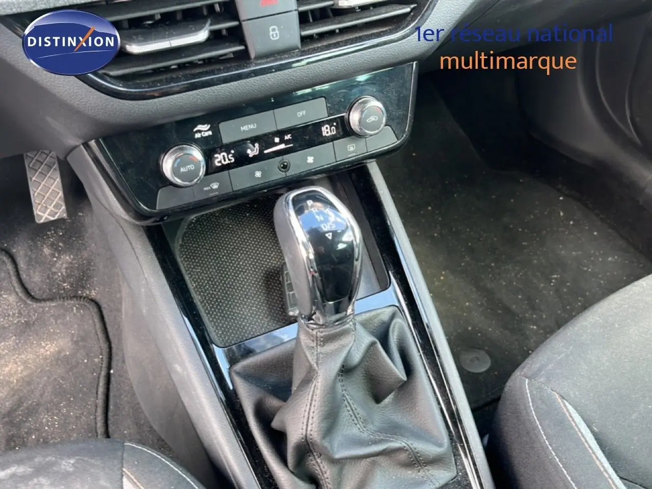 Gros plan sur la console centrale d’une Skoda Scala gris graphite, mettant en valeur le levier de vitesse automatique et la climatisation.
