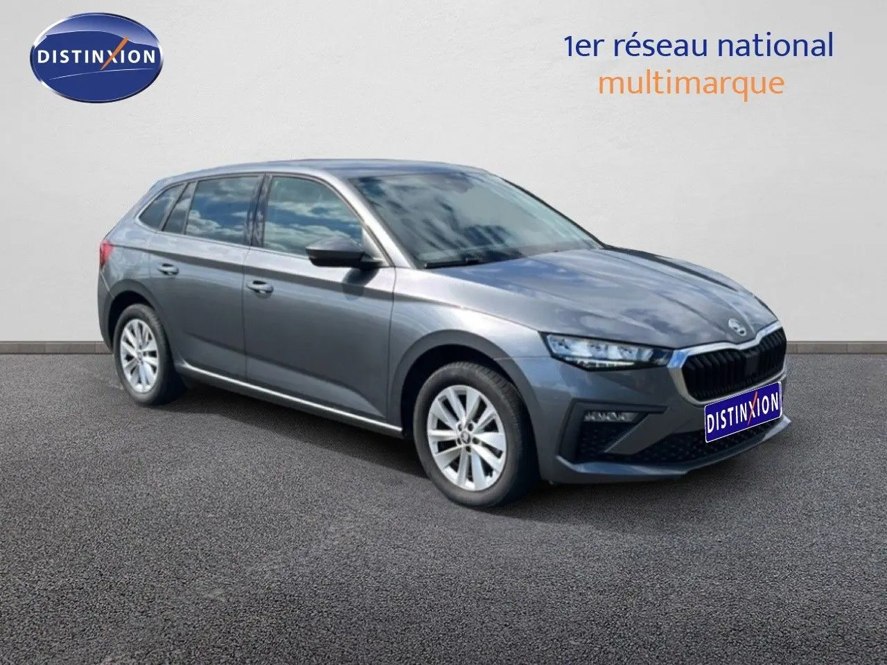Vue 3/4 avant droite d'une Skoda Scala gris graphite métal avec jantes alliage et calandre noire distinctive.